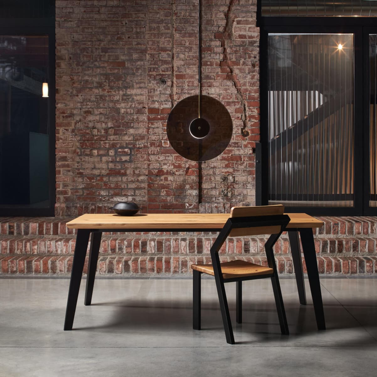 Designový jídelní stůl s kovovou židlí v moderním industriálním stylu.