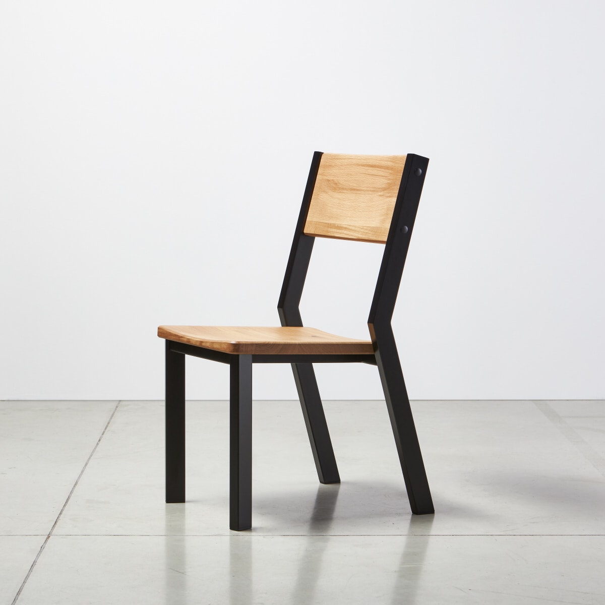Pevná židle k jídelnímu stolu s dubovým sedákem a černýma nohama